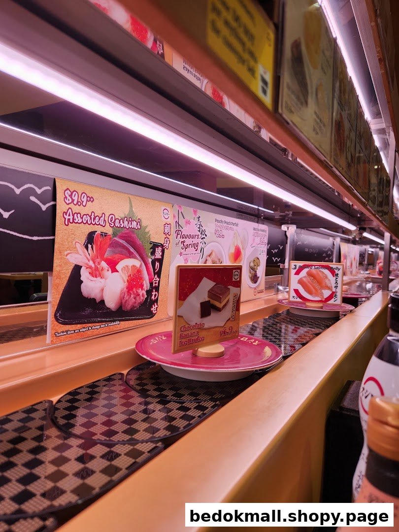 Interior view of a sushi restaurant with a conveyor belt and food displays.