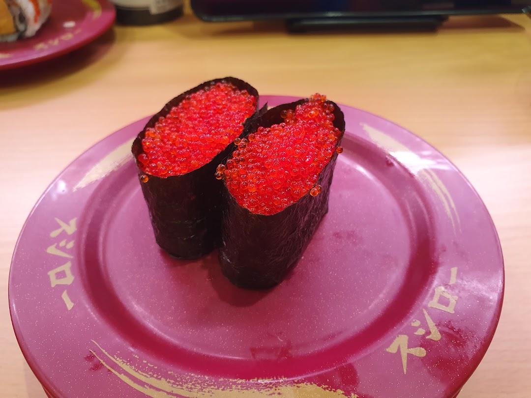 Two pieces of sushi with red roe on a purple plate.