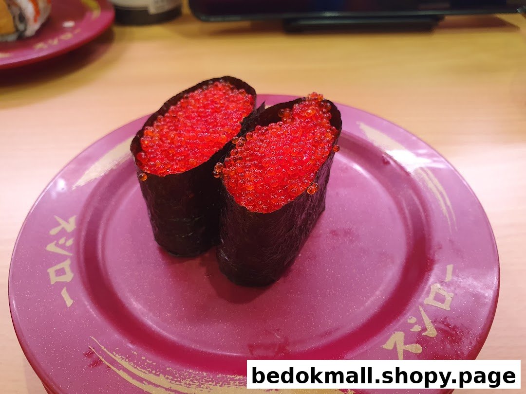 Two pieces of sushi with red roe on a purple plate.