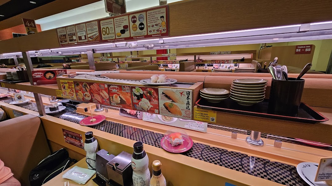 Interior view of a sushi restaurant with a conveyor belt system.