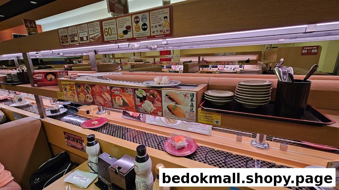 Interior view of a sushi restaurant with a conveyor belt system.