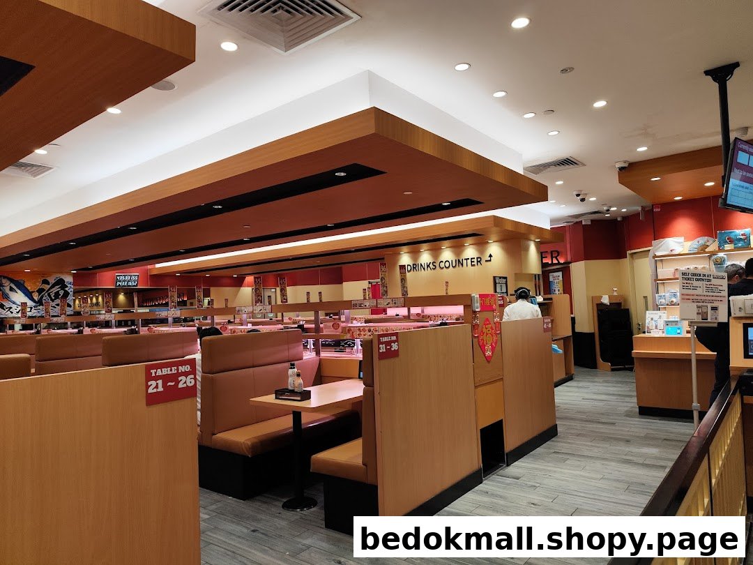 Interior of a sushi restaurant with dining booths and a conveyor belt system.