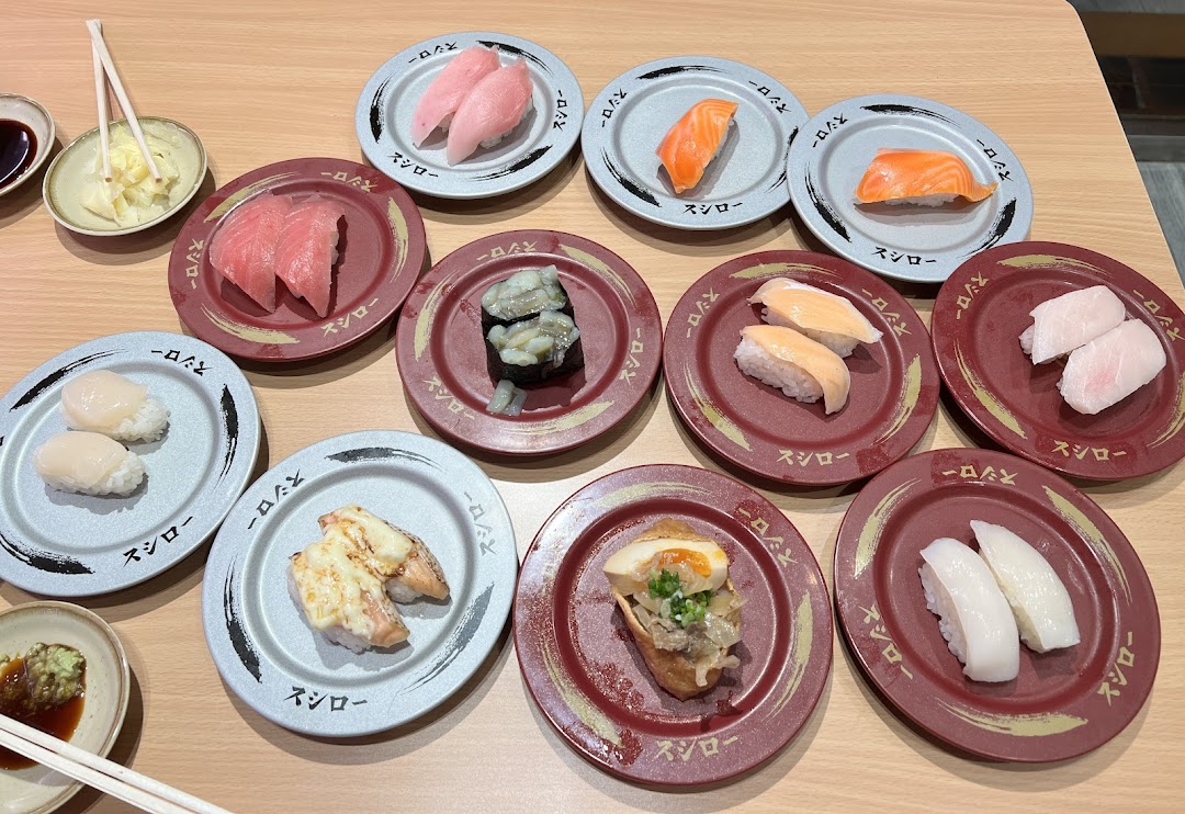 Various plates of sushi and other dishes on a table at Sushiro.