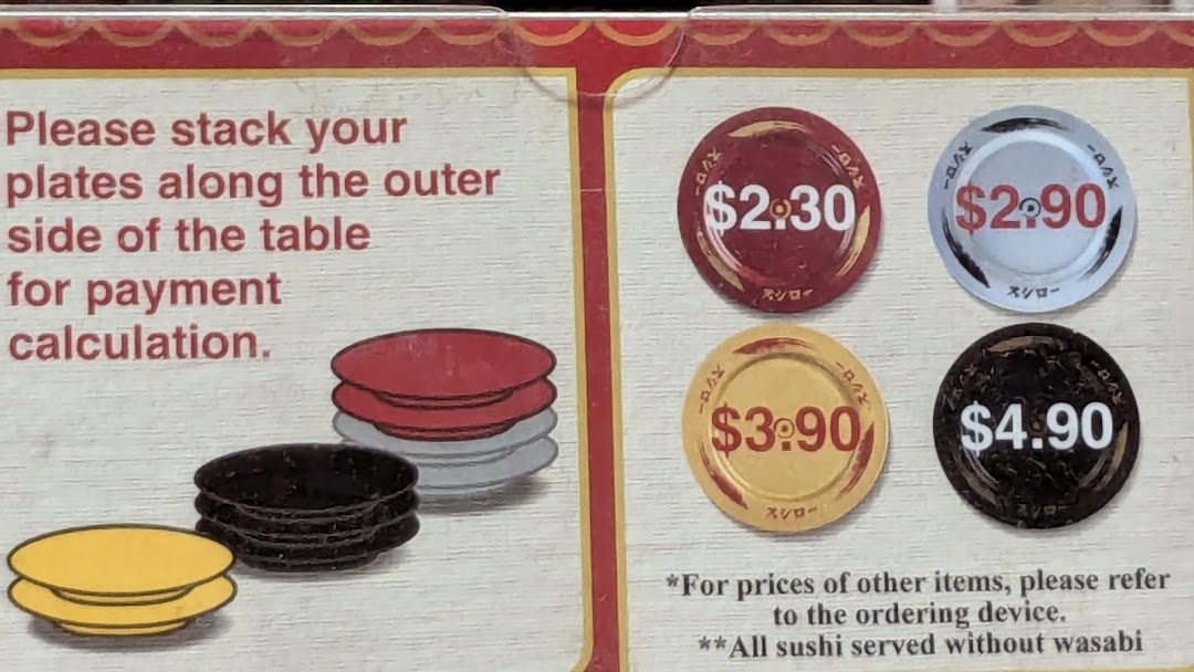 Sign showing plate stacking instructions and prices for different colored sushi plates.