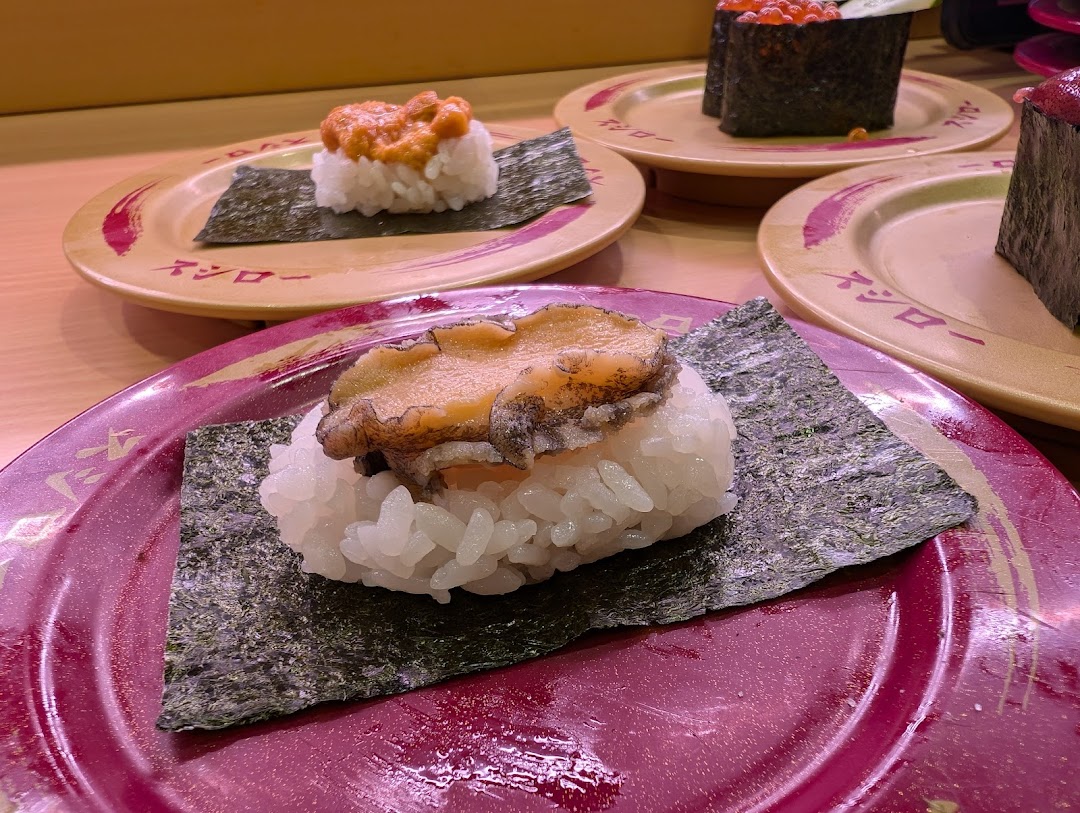 Close-up of various sushi dishes on plates at a restaurant.