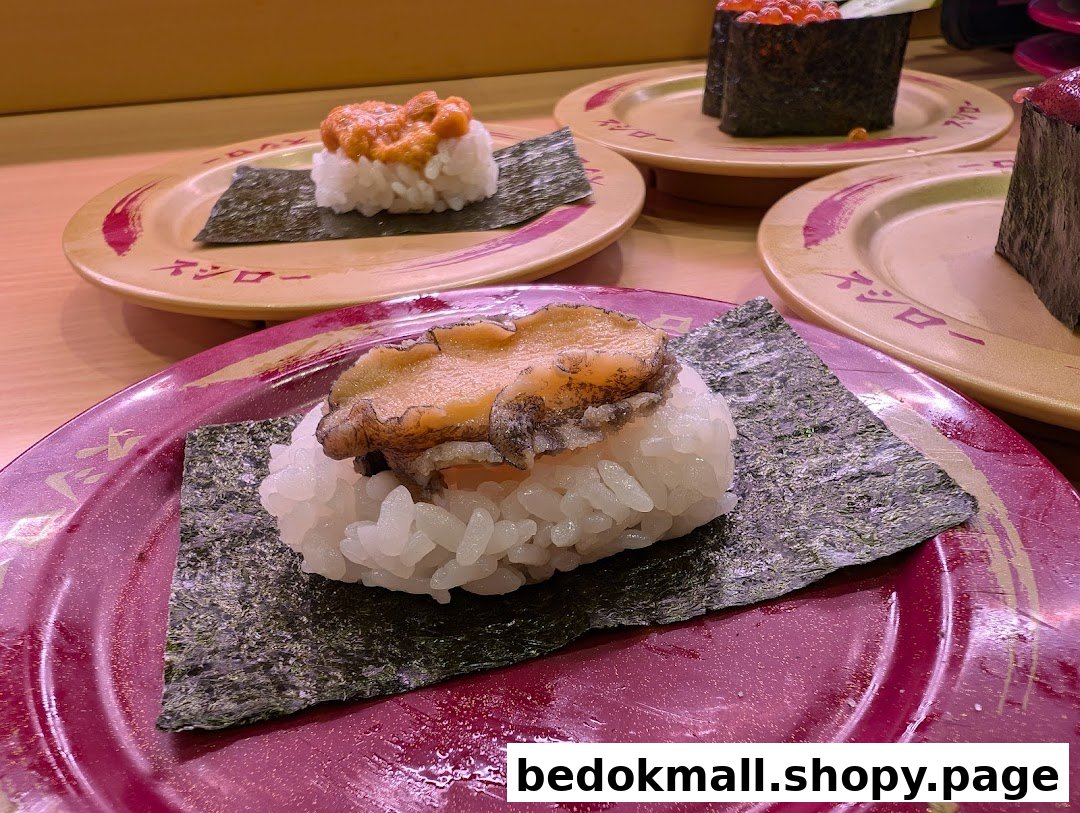 Close-up of various sushi dishes on plates at a restaurant.