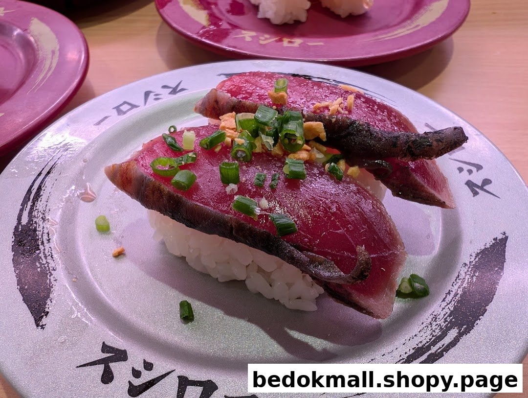 Close-up of seared tuna sushi on a plate, garnished with green onions.
