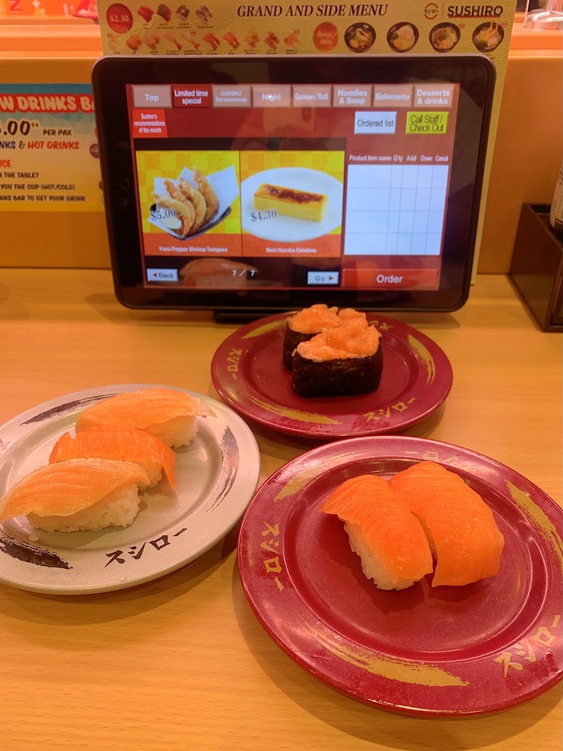 Sushi plates and an ordering tablet on a restaurant table.