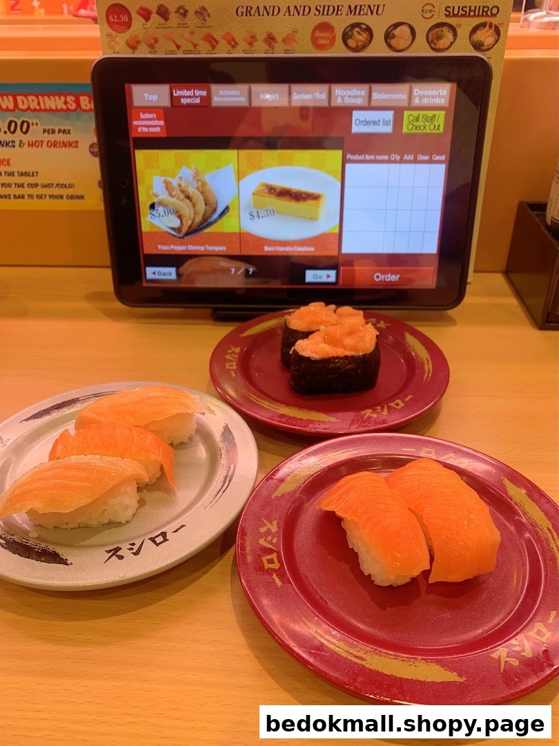 Sushi plates and an ordering tablet on a restaurant table.