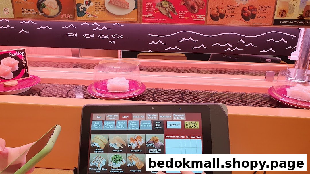 Sushi restaurant interior with conveyor belt and interactive ordering tablet.