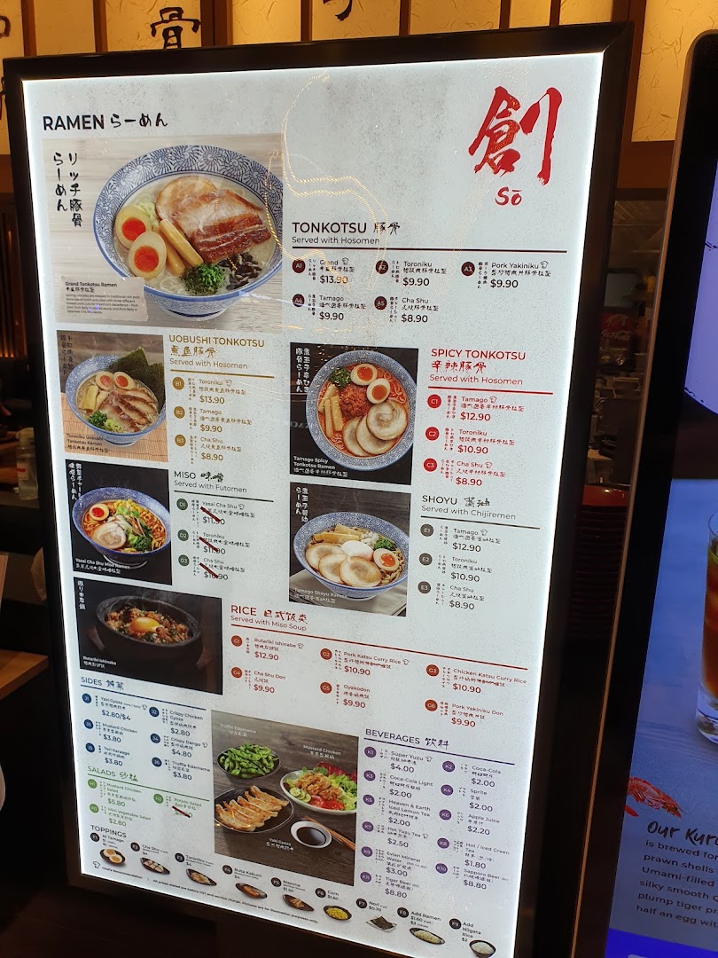 Illuminated menu board displaying ramen, rice, sides, and beverages with prices.