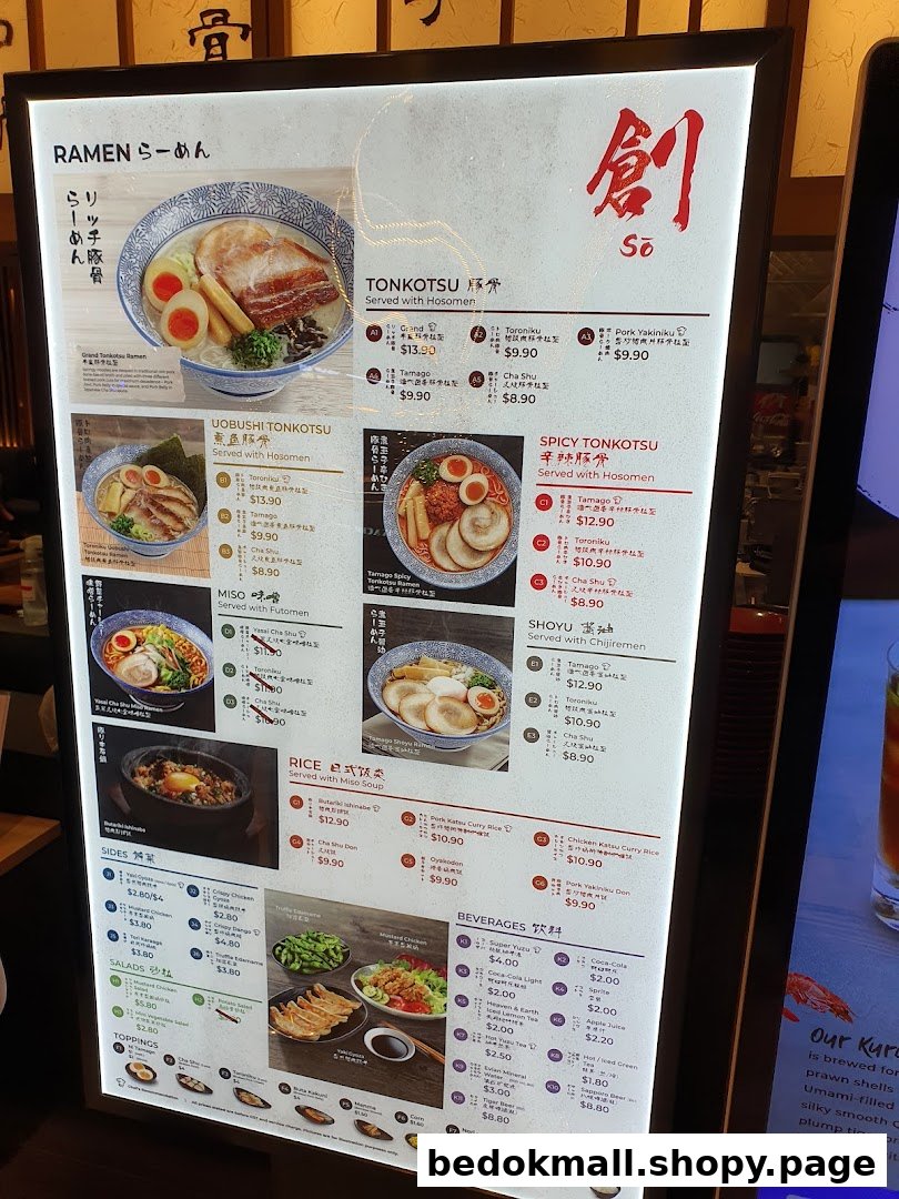 Illuminated menu board displaying ramen, rice, sides, and beverages with prices.