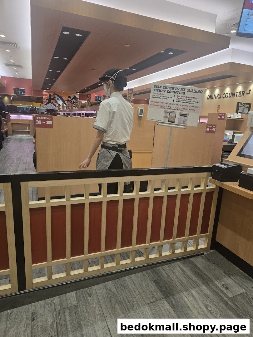 Interior view of a Sushiro restaurant with staff and a self-check-in counter.