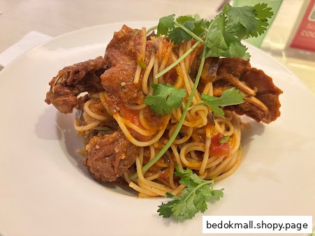 A plate of spaghetti with fried soft-shell crab and cilantro.