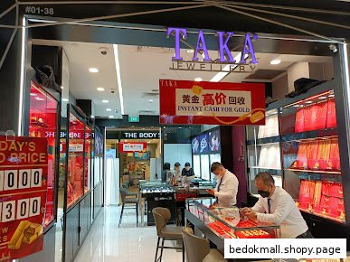 Entrance of a jewellery shop with display cases and staff inside.