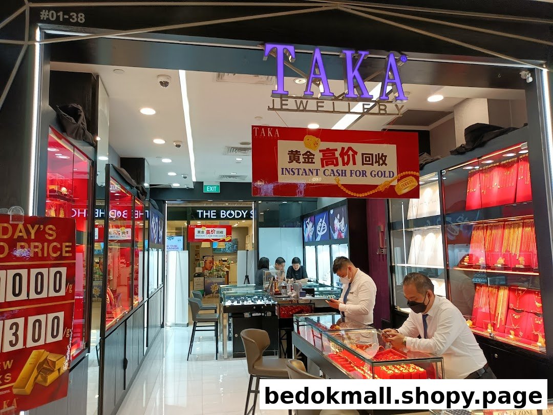 Interior of a jewellery shop with staff and display cases of gold items.