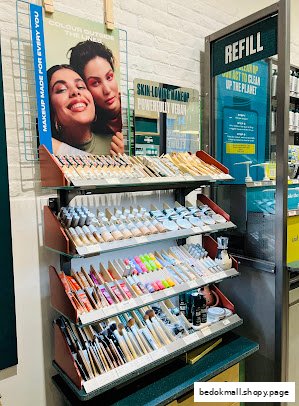 Interior shot of a Body Shop store with makeup displays and a refill station.