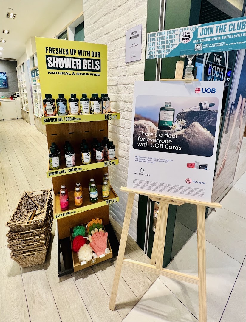 Shop interior showing a shower gel display and a promotional sign.