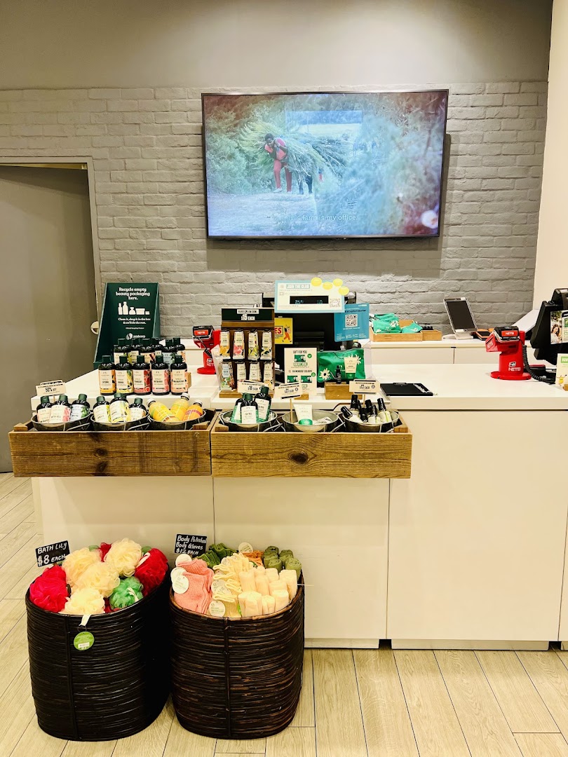 Shop interior with product displays, a counter, and a TV screen on the wall.