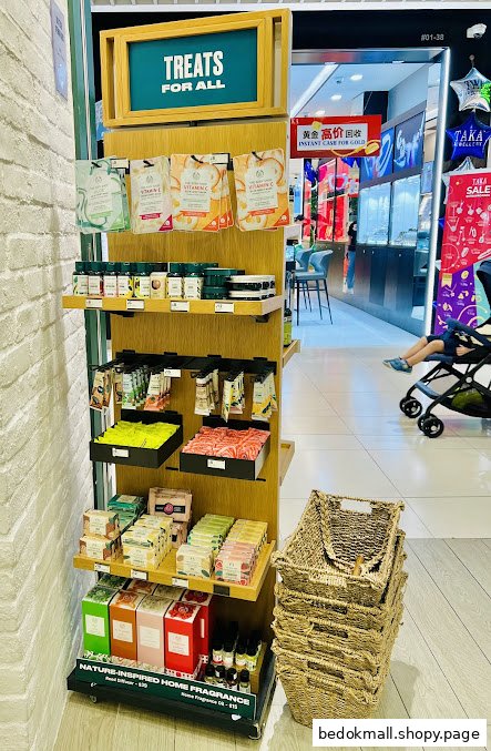 A retail display stand with Body Shop products inside a shopping mall.