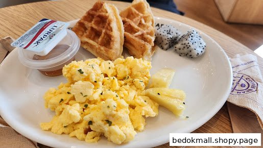 Plate with scrambled eggs, waffles, dragon fruit, and pineapple.