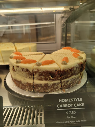 Carrot cake slices in a display case with a price tag.