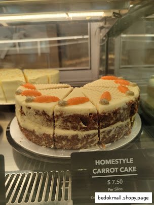 Carrot cake slices in a display case with a price tag.