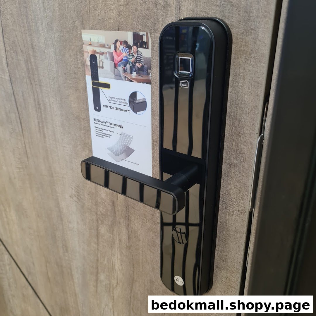 A black digital door lock with a product information sheet on a wooden display.