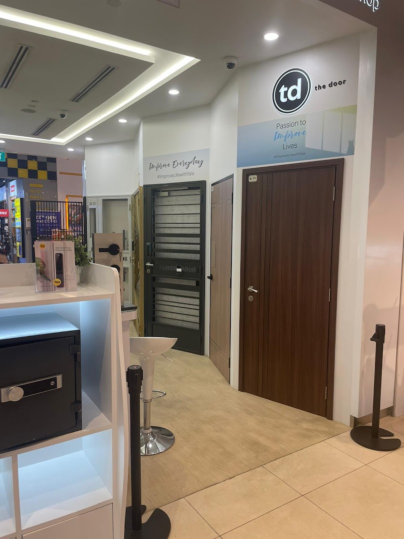Interior view of a shop displaying various doors, a safe, and branding.