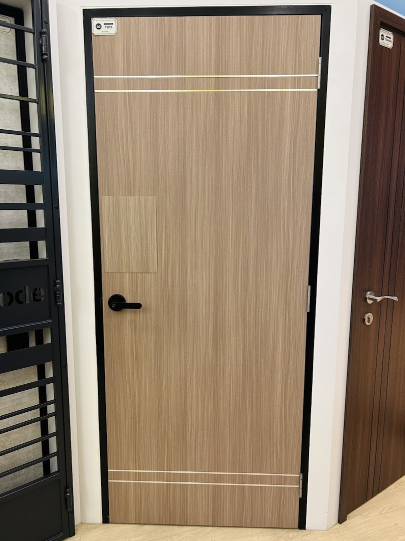 A light wood door with black handle and frame displayed in a showroom.