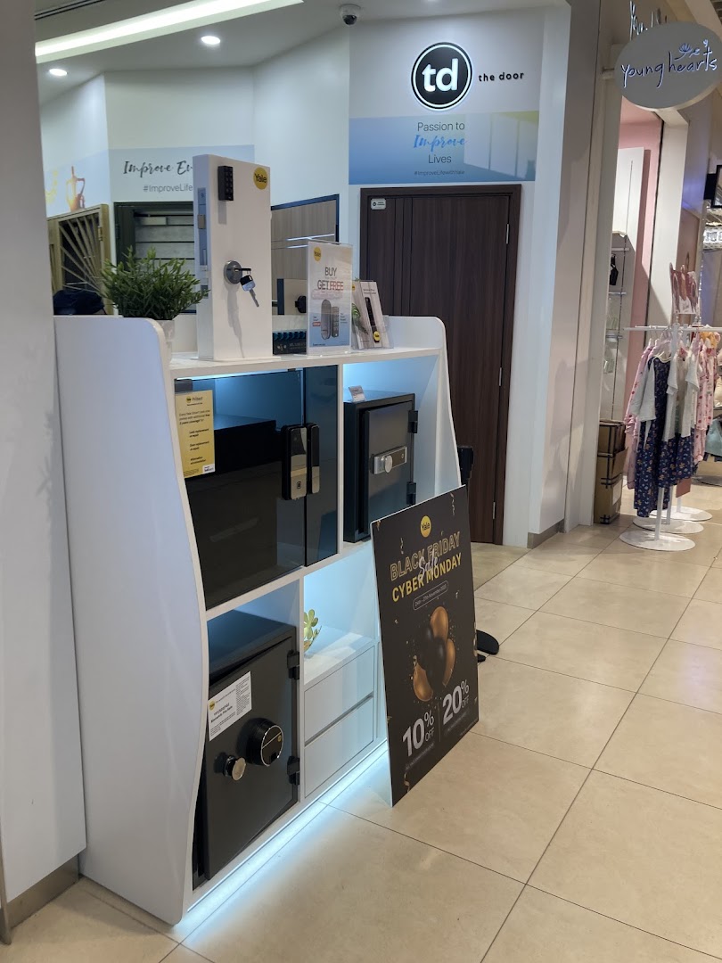 Display stand with security products and branding for 'The Door' in a mall.