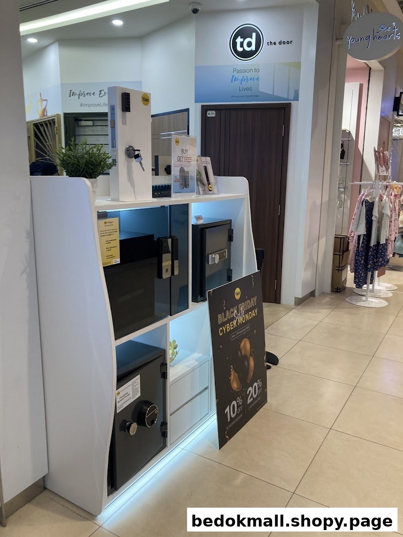 Display stand with security products and branding for 'The Door' in a mall.