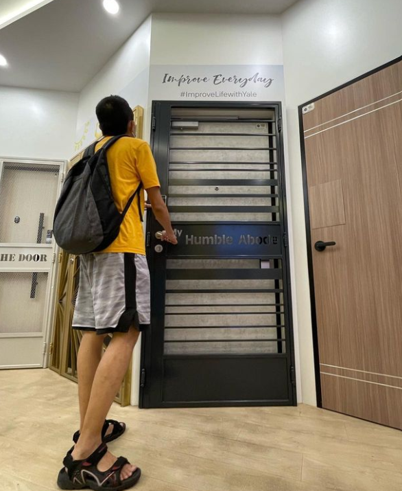 A person examines a display door inside a door showroom.