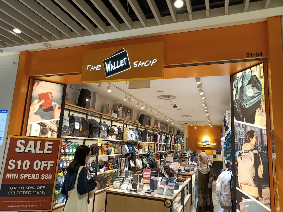 Shop entrance with products displayed and customers inside, featuring a sale sign.