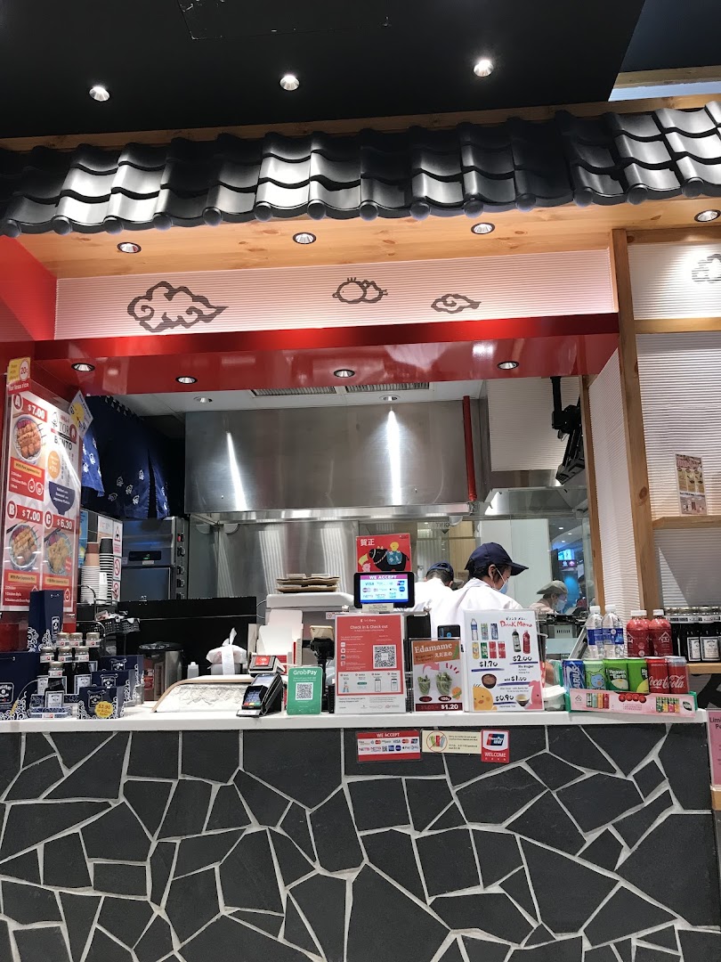 Interior view of a food stall counter with staff and payment area.