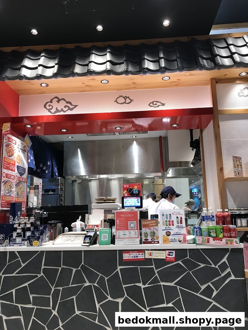 Interior view of a food stall counter with staff and payment area.