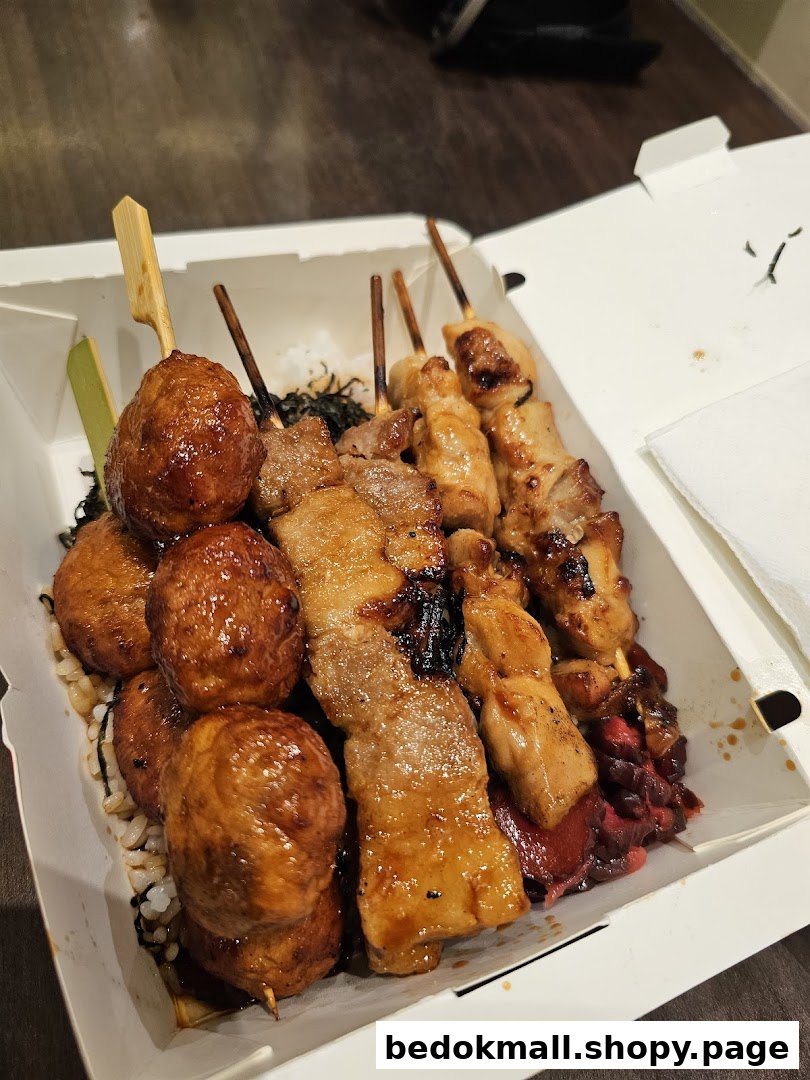 Takeaway box filled with various grilled meat skewers and rice.