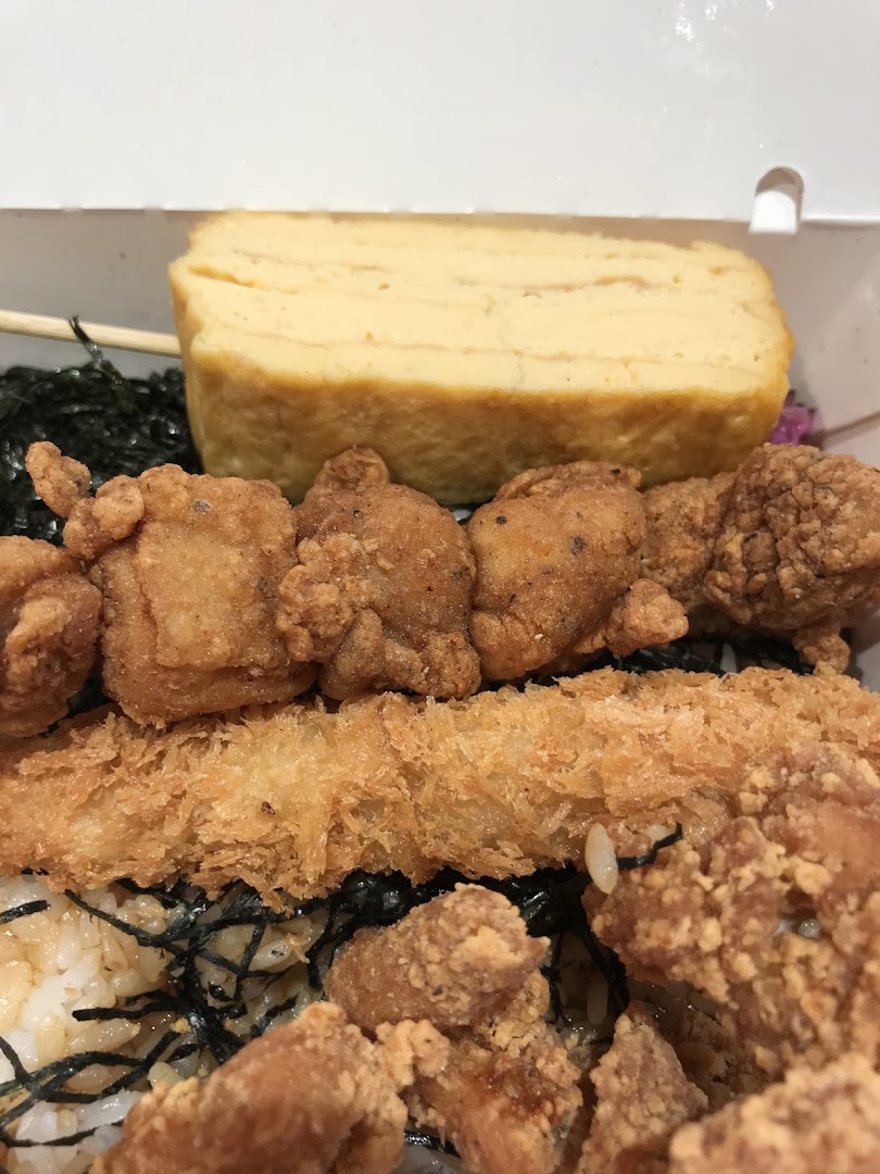 Close-up of a meal with fried chicken, fried cutlet, rice, and omelet.