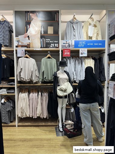 Interior view of a clothing store with racks, mannequins, and a customer.