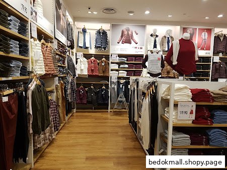 Retail store interior displaying clothing on racks, shelves, and mannequins.