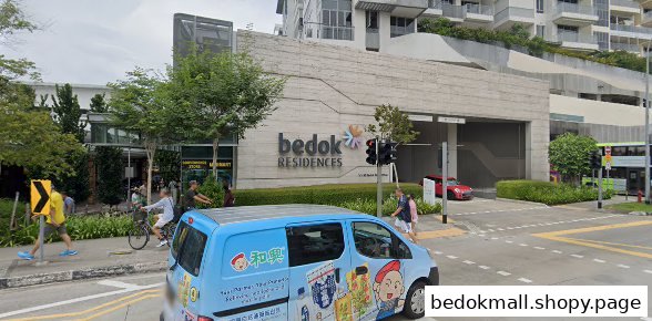 Street view of Bedok Residences building with people, a blue van, and traffic.