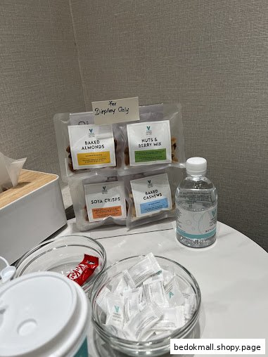 Table with packaged snacks, water, and other amenities for display.