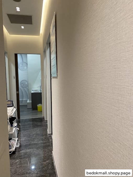 Interior hallway of a clinic with medical equipment and a door leading to a room.