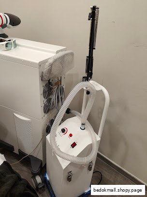 Medical aesthetic equipment, including a laser machine and cooling device, in a clinic room.