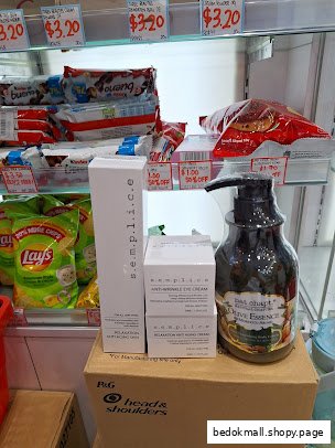 Various beauty products and snacks displayed on shelves in a shop.