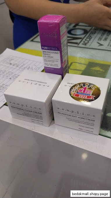 Skincare product boxes displayed on a counter with a person in the background.