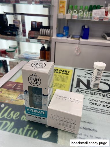 Two product boxes on a shop counter with shelves of products in the background.