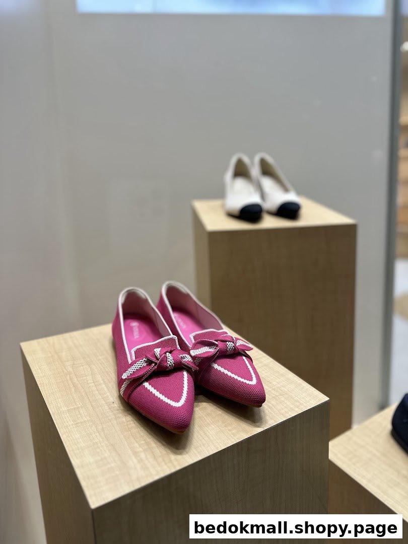 Pink and white shoes displayed on wooden pedestals inside a shop.