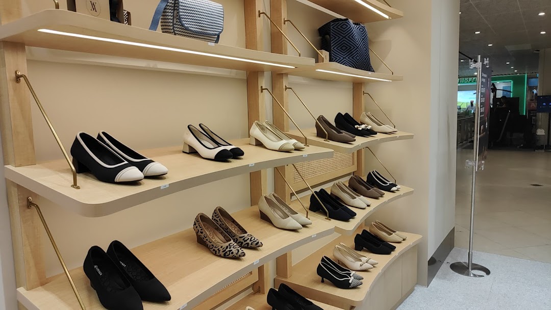 Interior view of a shoe store with multiple pairs of shoes on display shelves.