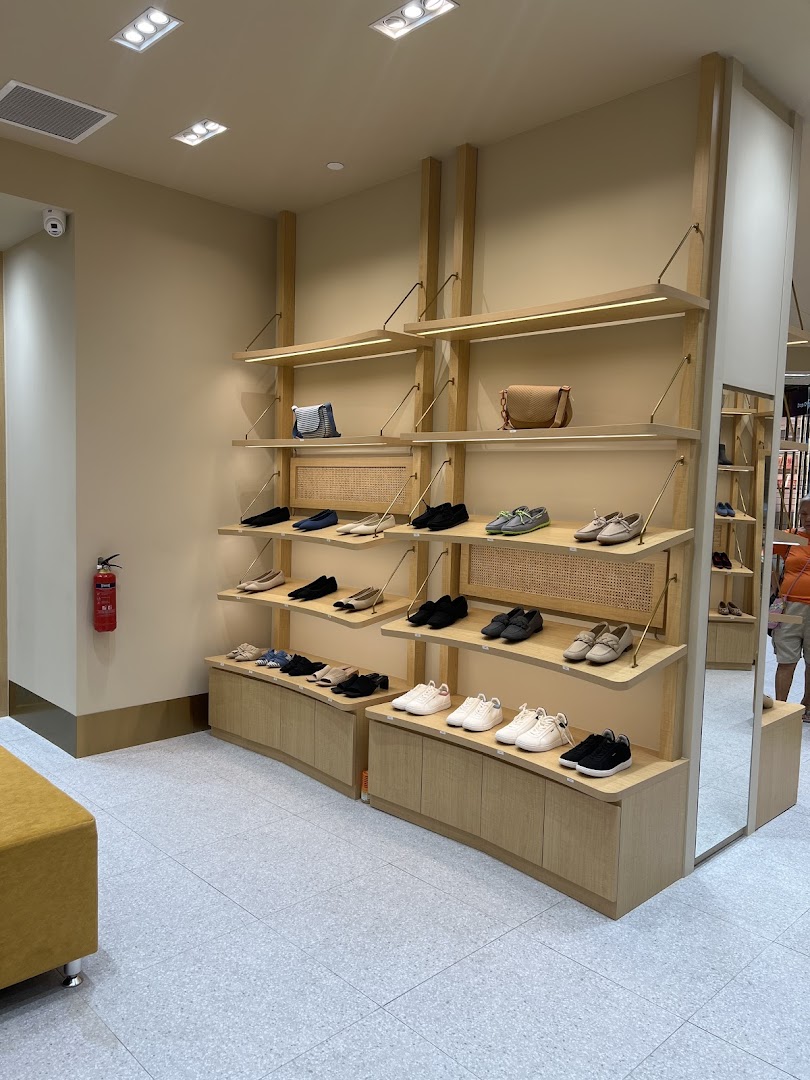Interior view of a shoe store with shoes and bags displayed on shelves.